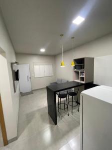 a kitchen with a black table and chairs in a room at Vêneto Flat Residence (AP-13) in Primavera do Leste
