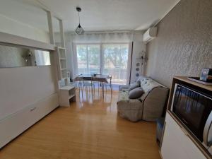 a living room with a couch and a table at Studio cabine Canet Plage Parking in Canet-en-Roussillon