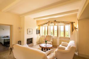 a living room with white furniture and a fireplace at Villa La Passione Charme House in Venarotta