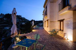 a patio with chairs and an umbrella next to a building at Bajo El Cejo in El Berro