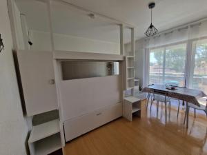 a kitchen and dining room with a table and a shelf at Studio cabine Canet Plage Parking in Canet-en-Roussillon