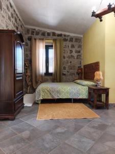ein Schlafzimmer mit einem Bett und einer Steinmauer in der Unterkunft Pinnettu Ghilarza in Ghilarza
