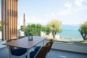 a table and chairs with a view of the ocean at La Mer Bleue Beachfront Boutique Apartments in Vrahati