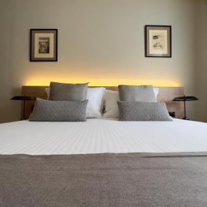 Una cama blanca grande con dos almohadas encima. en Potnia Athens, en Atenas