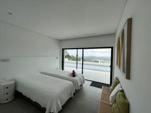 2 letti in una camera da letto con una grande finestra di villagoldra rentals - Luxury and Family Villa a Goldra de Baixo