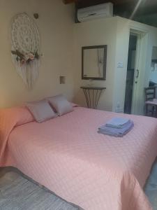 - une chambre avec un lit rose et 2 serviettes dans l'établissement Eleni's Cottage, à Apsiou