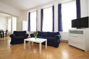プラハにあるQuadrio Bedroom Central Apartmentのリビングルーム(青い椅子2脚、テレビ付)