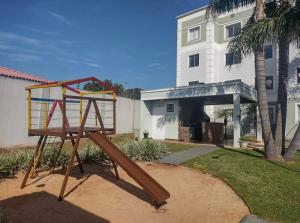 um parque infantil num quintal ao lado de uma casa em Apartamento novo wi-fi + TV em Ponta Grossa