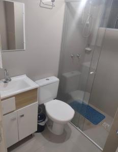 y baño con aseo, ducha y lavamanos. en Apartamento novo wi-fi + TV, en Ponta Grossa