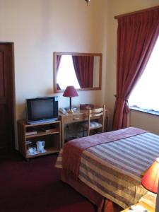 una habitación de hotel con una cama y un televisor en Laings Lodge, en Laingsburg