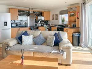 a living room with a couch and a kitchen at Heddfan in Llanelli