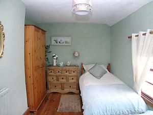 a bedroom with a bed and a wooden dresser at Thistle-doo Nicely in Staithes