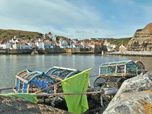 a group of boats parked on the shore of a body of water at Thistle-doo Nicely in Staithes