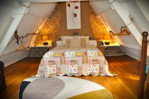 um quarto com uma cama grande num sótão em Gîte Les Pierres Blondes em Groléjac