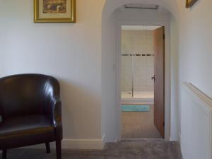 Unstone的住宿－Boundary Cottage，走廊上带浴室的黑色皮椅
