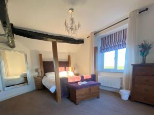 a bedroom with a bed and a large mirror at Boundary Cottage in Unstone