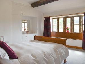 een slaapkamer met een wit bed en een raam bij Higher Kirkstall Wood Farm in Ingrow