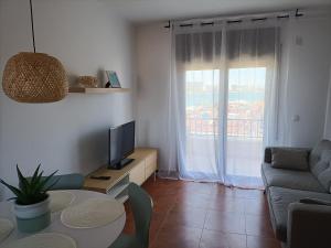 a living room with a couch and a tv and a table at Riells mar in L'Escala