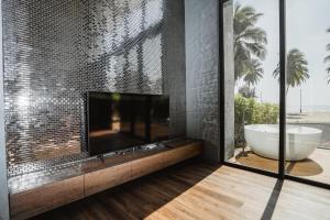 a bathroom with a bath tub and a fireplace at The Bloc @ Sea in Thap Sakae