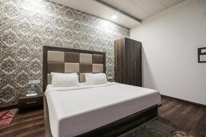 a bedroom with a large bed and a wall at Super Townhouse 561 Hotel Hollywood Heights in Amritsar
