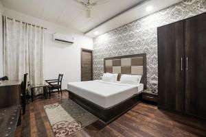 a bedroom with a bed and a chair in it at Super Townhouse 561 Hotel Hollywood Heights in Amritsar