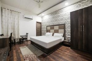Un dormitorio con una cama y una silla dentro. en Townhouse Hollywood Heights, en Amritsar