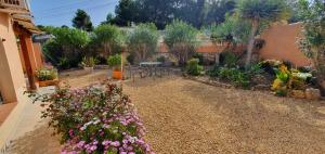 een tuin met een tafel en wat bloemen bij Cheerful 2-bedroom villa with private pool in Calpe