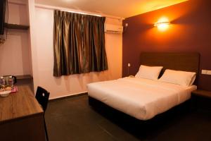 A bed or beds in a room at Micasa Hotel Labuan