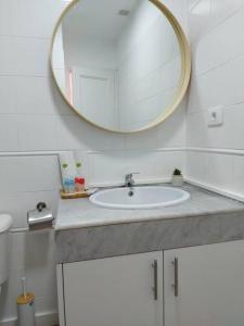 y baño con lavabo y espejo. en Puerta Del Sol Casa Ilaria, en Caleta de Fuste