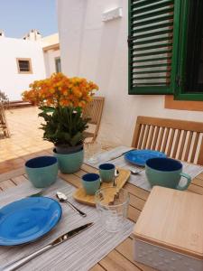 una mesa con platos azules y flores en ella en Puerta Del Sol Casa Ilaria, en Caleta de Fuste