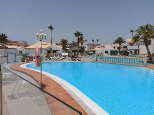 una gran piscina en un complejo con palmeras en Puerta Del Sol Casa Ilaria, en Caleta de Fuste