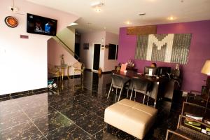 a living room with a table and a purple wall at Micasa Hotel Labuan in Labuan