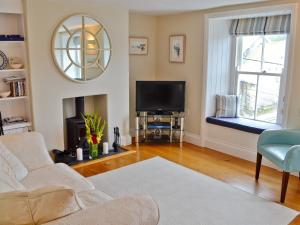 a living room with a couch and a tv at Mainbrace in Port Isaac