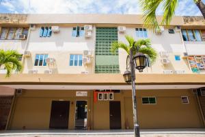 a building with a palm tree and a street light at Micasa Hotel Labuan in Labuan