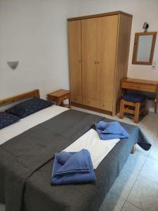 Un dormitorio con una cama con toallas azules. en Mata's House, en Skiathos