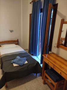 Un dormitorio con una cama y un escritorio con una camisa azul. en Mata's House en Skiathos