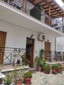 a building with potted plants on the floor and a balcony at Mata's House in Skiathos