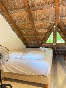 a bedroom with a bed with a straw roof at La Constanza de Rulo in Holbox Island