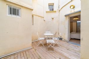 a patio with a table and chairs on a deck at Un pied à terre avec terrasse à la Cathédrale - Une Nuit à Nîmes in Nîmes