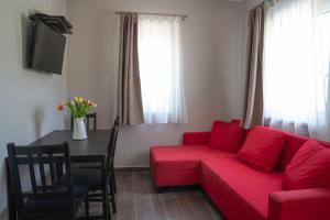 エゲルにあるTulipán Apartmanのリビングルーム(赤いソファ、テーブル付)