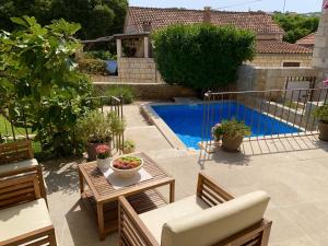 a patio with a table and chairs and a pool at Heritage house Dvor in Sutivan