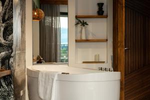 a bathroom with a white tub and a mirror at Celestino Boutique Hotel in Medellín