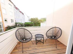 2 Stühle und ein Stuhl auf dem Balkon in der Unterkunft 69 m², zentral, Balkon, stilvoll in Osnabrück
