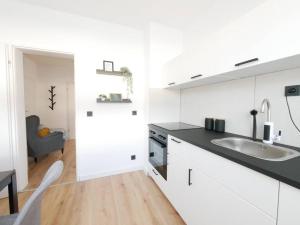 a white kitchen with a sink and a counter at 69 m², zentral, Balkon, stilvoll in Osnabrück