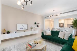 een woonkamer met een groene bank en een tafel bij Ultimate Stay / Burj Al Arab View / Brand New / Amazing Pool with a View / Perfect Holiday / Madinat Jumeirah / 2 BDR in Dubai