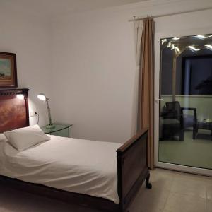 um quarto com uma cama, uma cadeira e uma janela em Flat in Porto Cristo center 350 mt. beach Strand em Porto Cristo