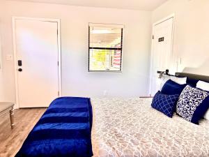 a bedroom with a bed with blue pillows and a window at Upgraded, Stylish & Comfy 1 Bedroom/1 Bath Studio in Payson