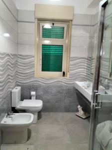 baño con aseo y lavabo y ventana en Maremonti, en Zafferana Etnea