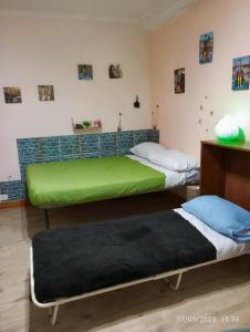 2 camas en una habitación con colchón verde en Salotto Partenopeo, en Nápoles