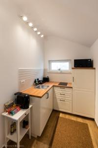 a kitchen with white cabinets and a sink and a window at Red Fountain Studio in Braşov